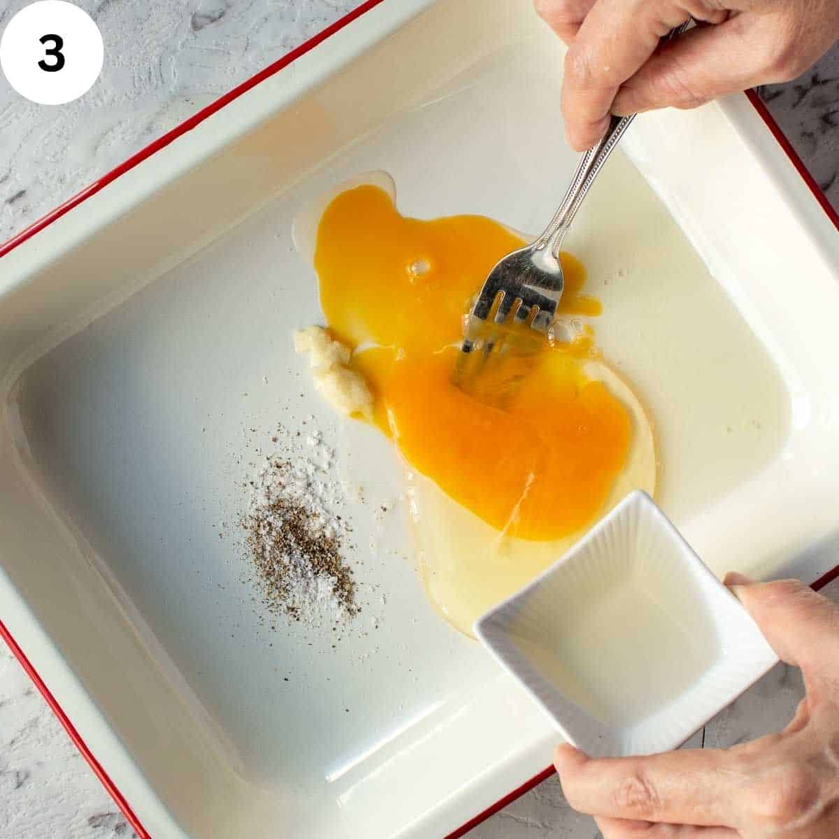 Whisking an egg with other ingredients.