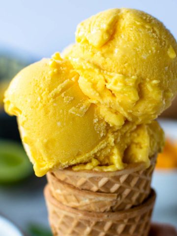 ice cream cone with three scoops of yellow ice cream.