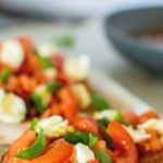 images with text. text reads "italian classic bruschetta with mozzarella. image is bruschetta with tomatoes and mozzarella on white plate.