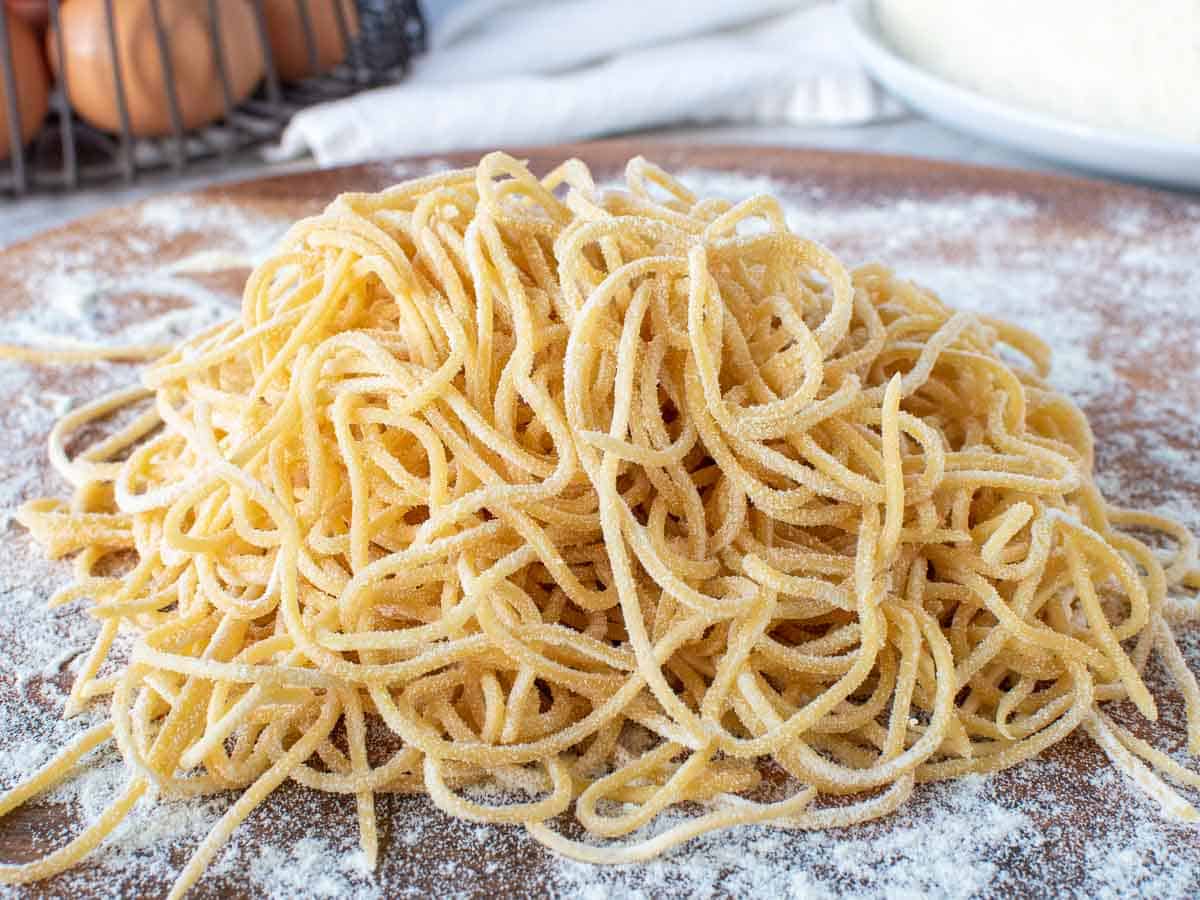 pile of homemade tonnarelli pasta on a floured bench