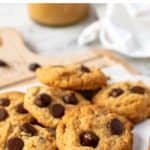 image with text. text reads "gluten free almond flour peanut butter cookies'. image is cookies topped with chocolate chips on white baking baking.