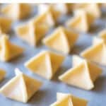 image with text. text reads "cheesy filled pasta handmade fagottini". image is pyramid shaped filled pasta on white baking paper.