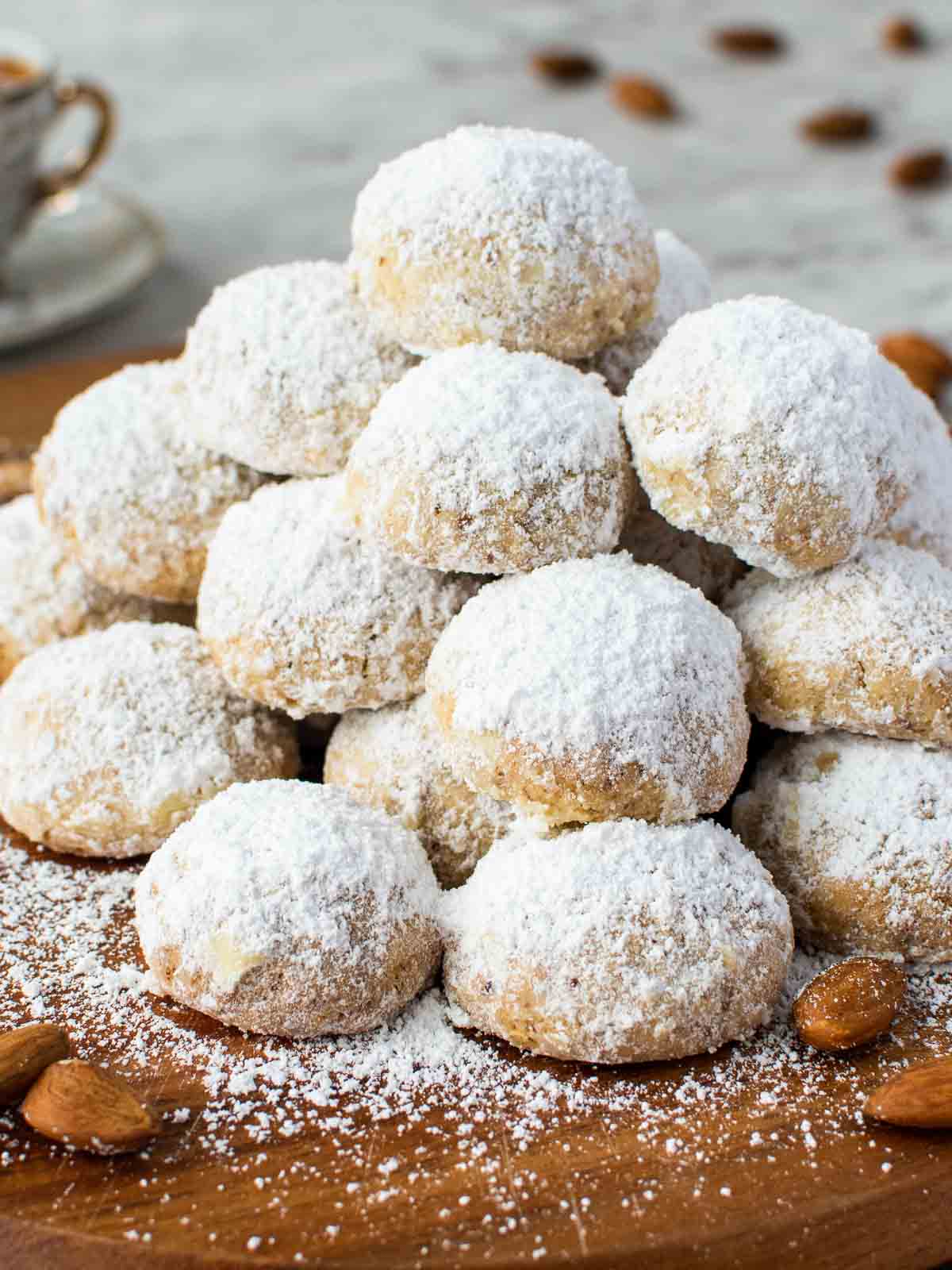 Italian Wedding Cookies pile onto a wooden board.