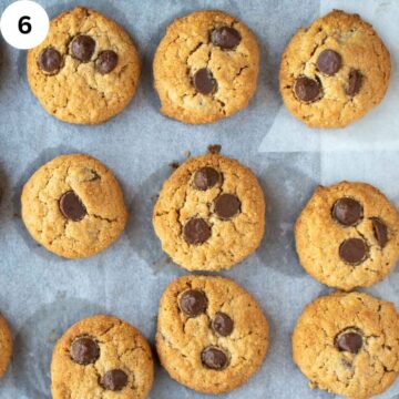 Baked cookies with chocolate chips on a baking sheet viewed from above.