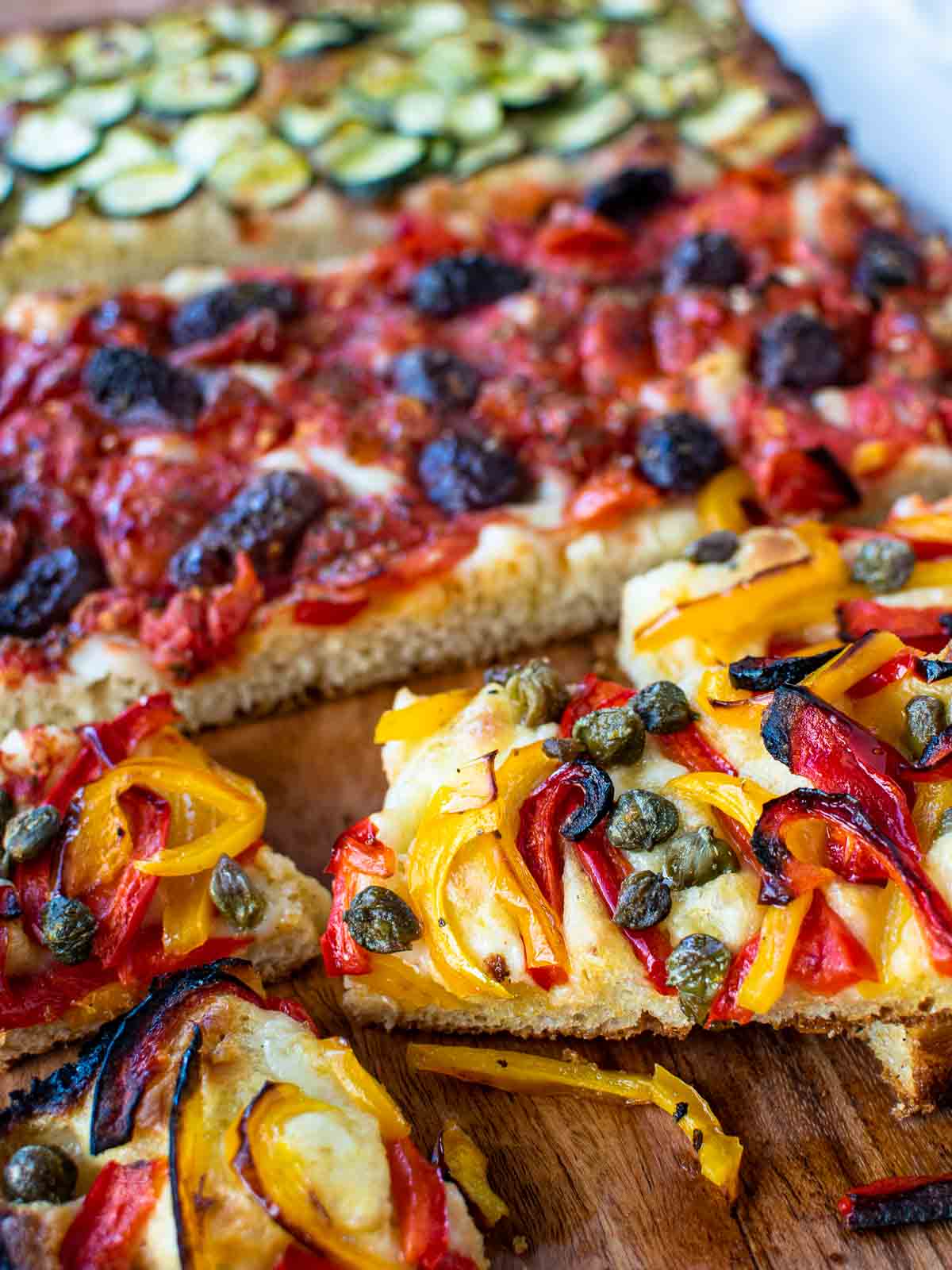 Focaccia toppings of sweet peppers, capers, olives and tomatoes.