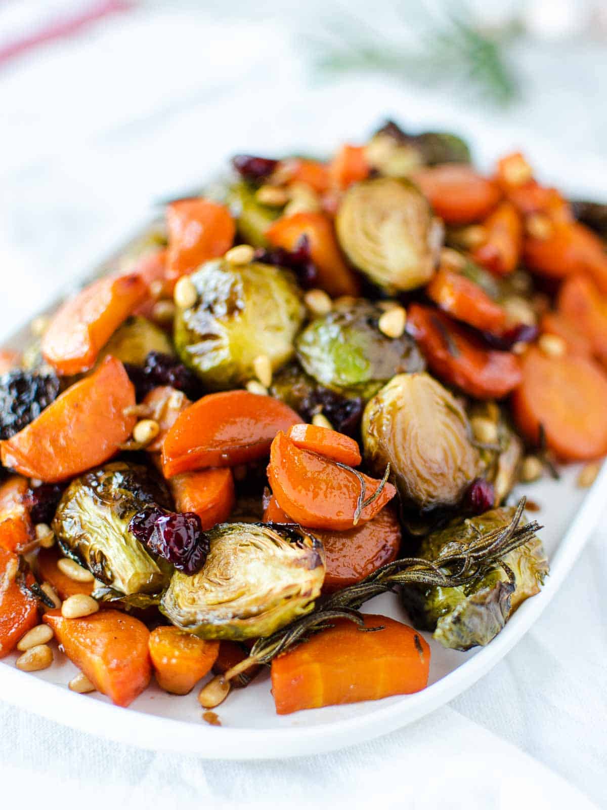 roasted carrots and brussels sprouts on white oblong plate.