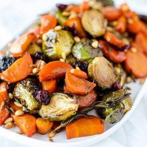 roasted carrots and brussel sprouts on white oblong plate.