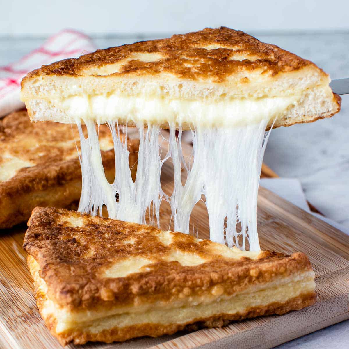 fried cheese sandwich cut in half and showing cheese pull.