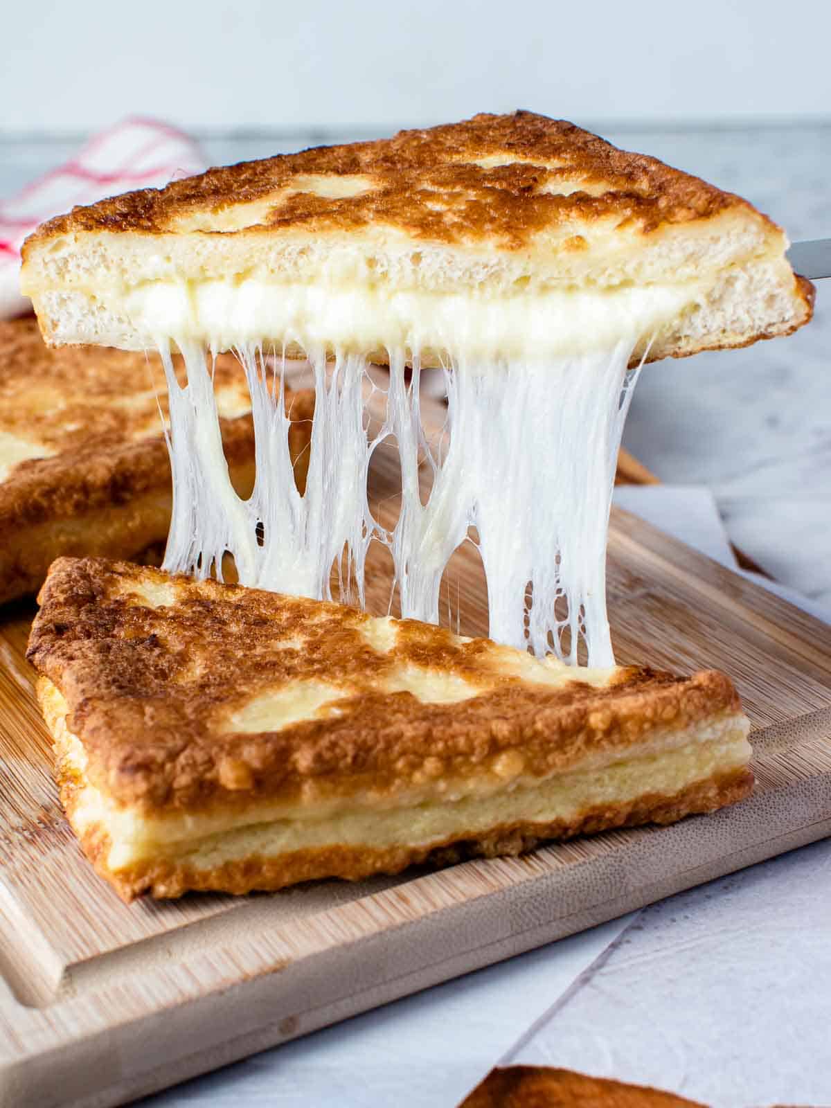 Mozzarella in carrozza cut in half and showing cheese pull.