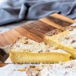 image with text. text reads "creamy and luscious torta della nonna". image is pie with pastry cream filling with a slice cut and pulled out.
