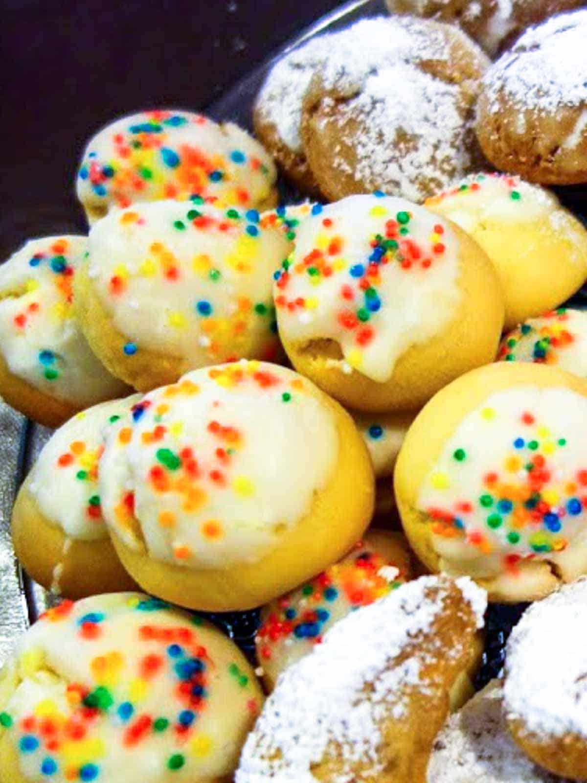 cookies with white hard frosting and colored jimmies with other cookies surrounding.