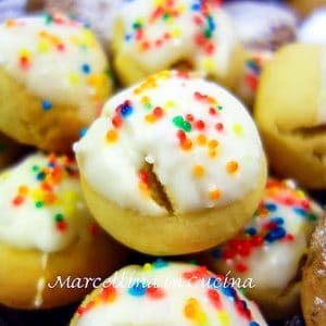close up of cookies with white icing and sprinkles.