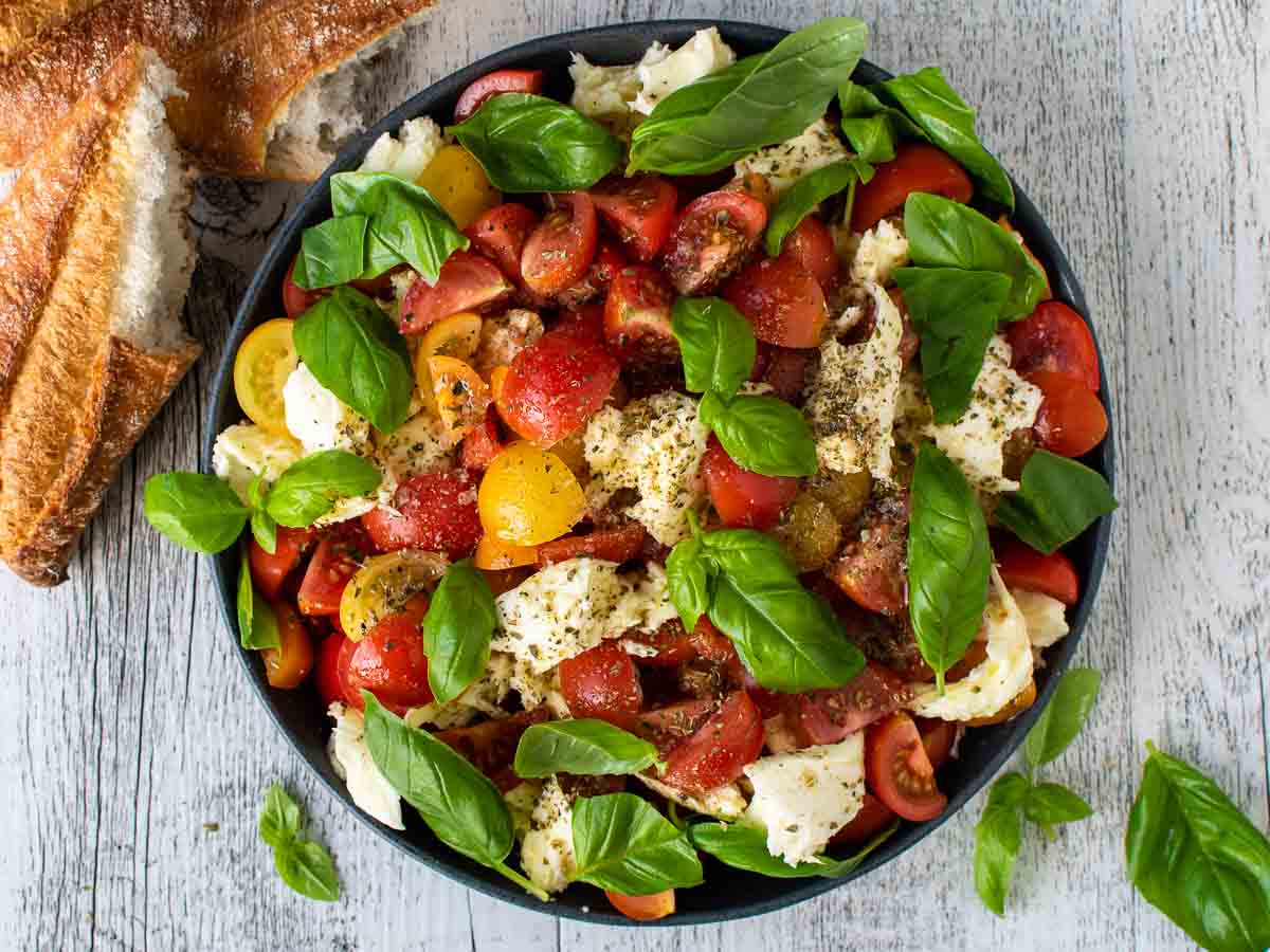 Overhead view of tomato, basil and mozzarella salad in a shallow bowl.