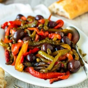 White plate of multi colored strips of fried bell peppers.