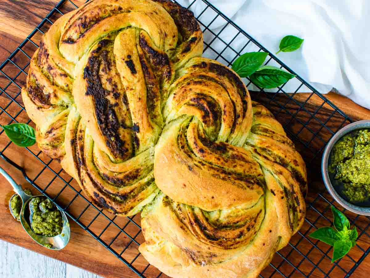 Braided bread on black wire rack viewed from above.