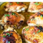 Baked Italian chicken thighs in baking pan garnished with parsley.