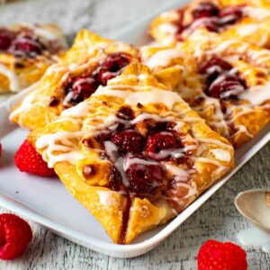 Raspberry Danish pastries on white plate.