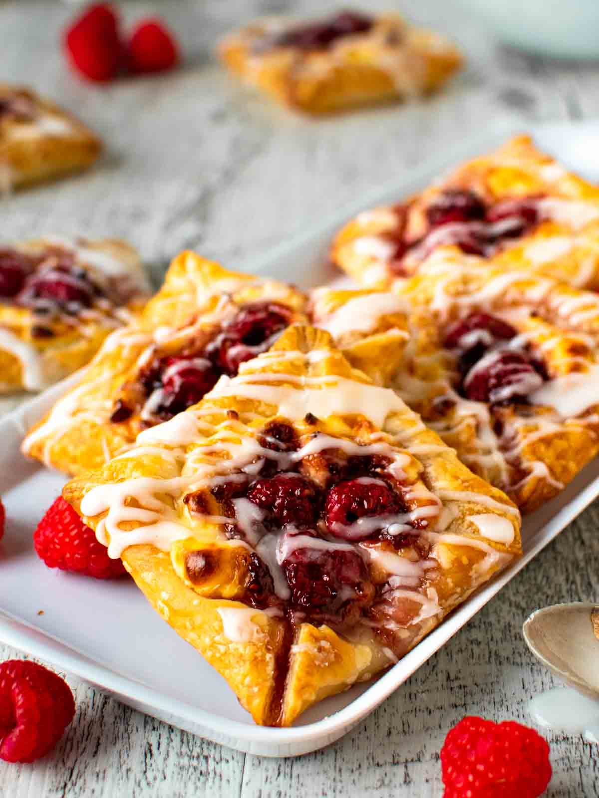 Raspberry Danish pastries on white plate.