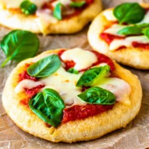 Three pizza fritta in a staggered row with tomato sauce, cheese and basil leaves.