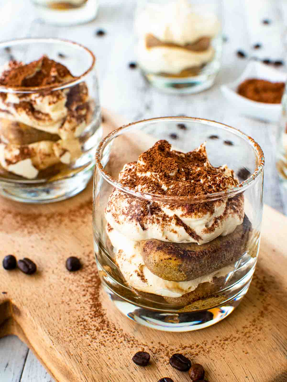 Tiramisu cups on wooden board.