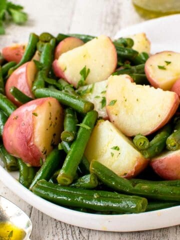 Green beans and potatoes on a white plate.