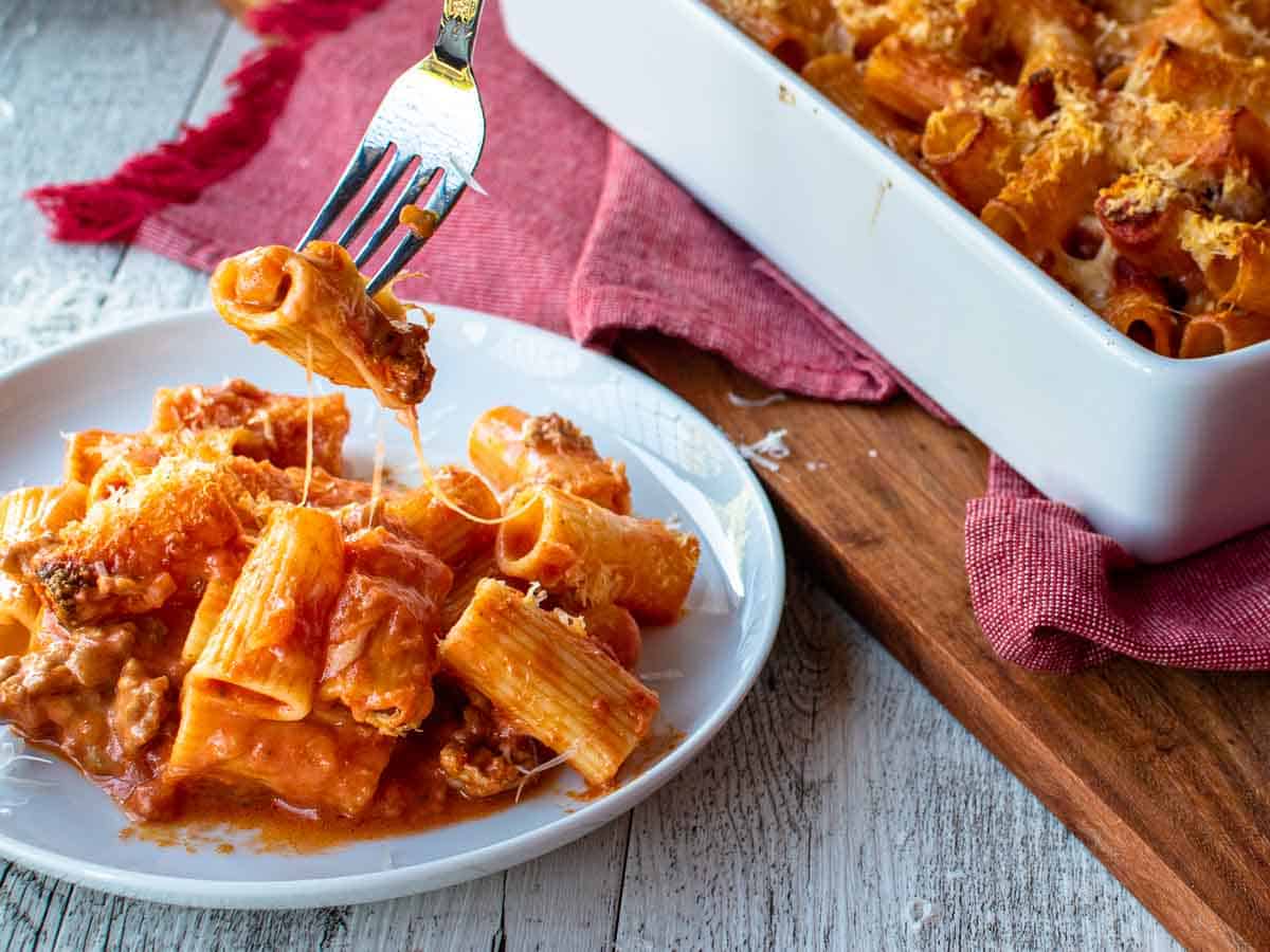 Baked rigatoni pasta on a white plate.