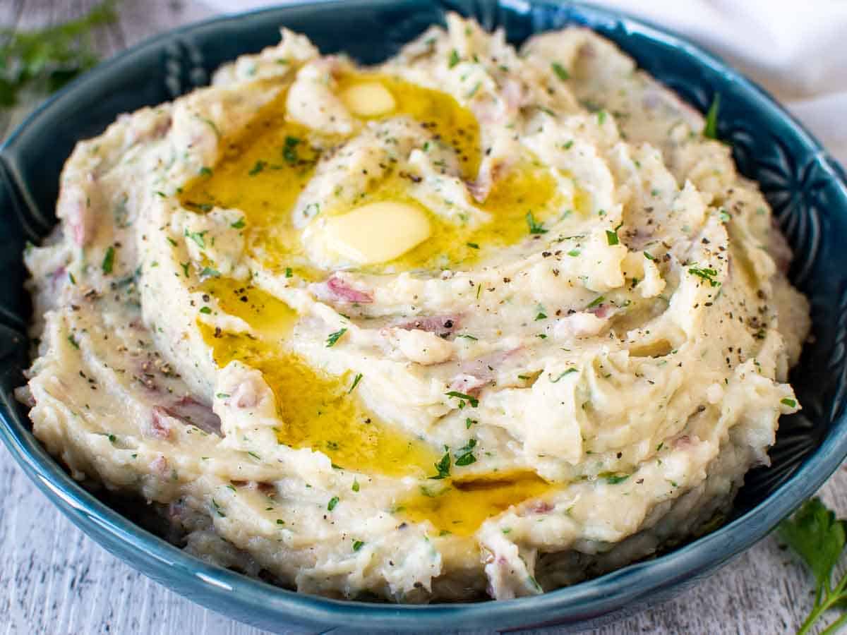 Close up view of mashed potatoes in a blue bowl.