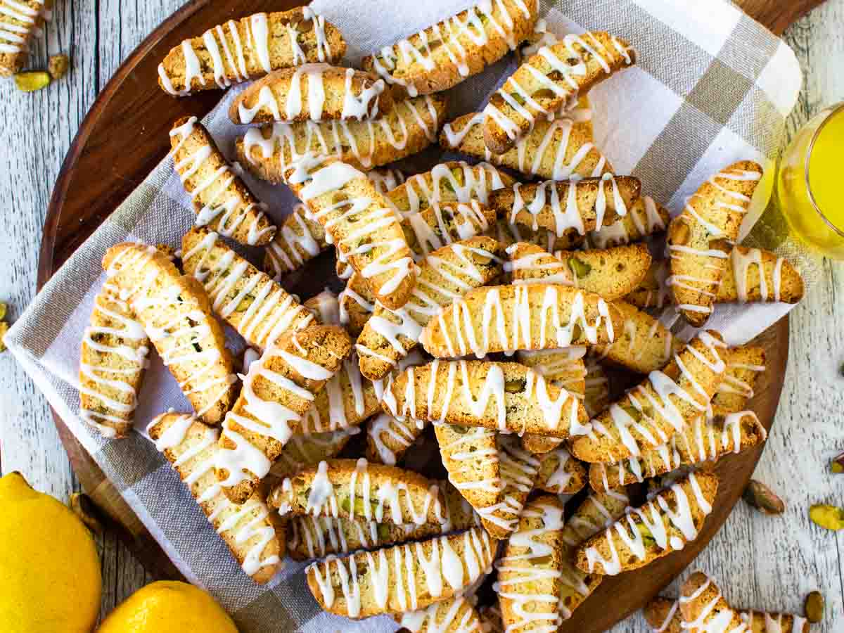 Overhead view of a pile of biscotti with white icing drizzle on each.