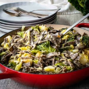 Pizzoccheri pasta with cabbage and potatoes in red pan.
