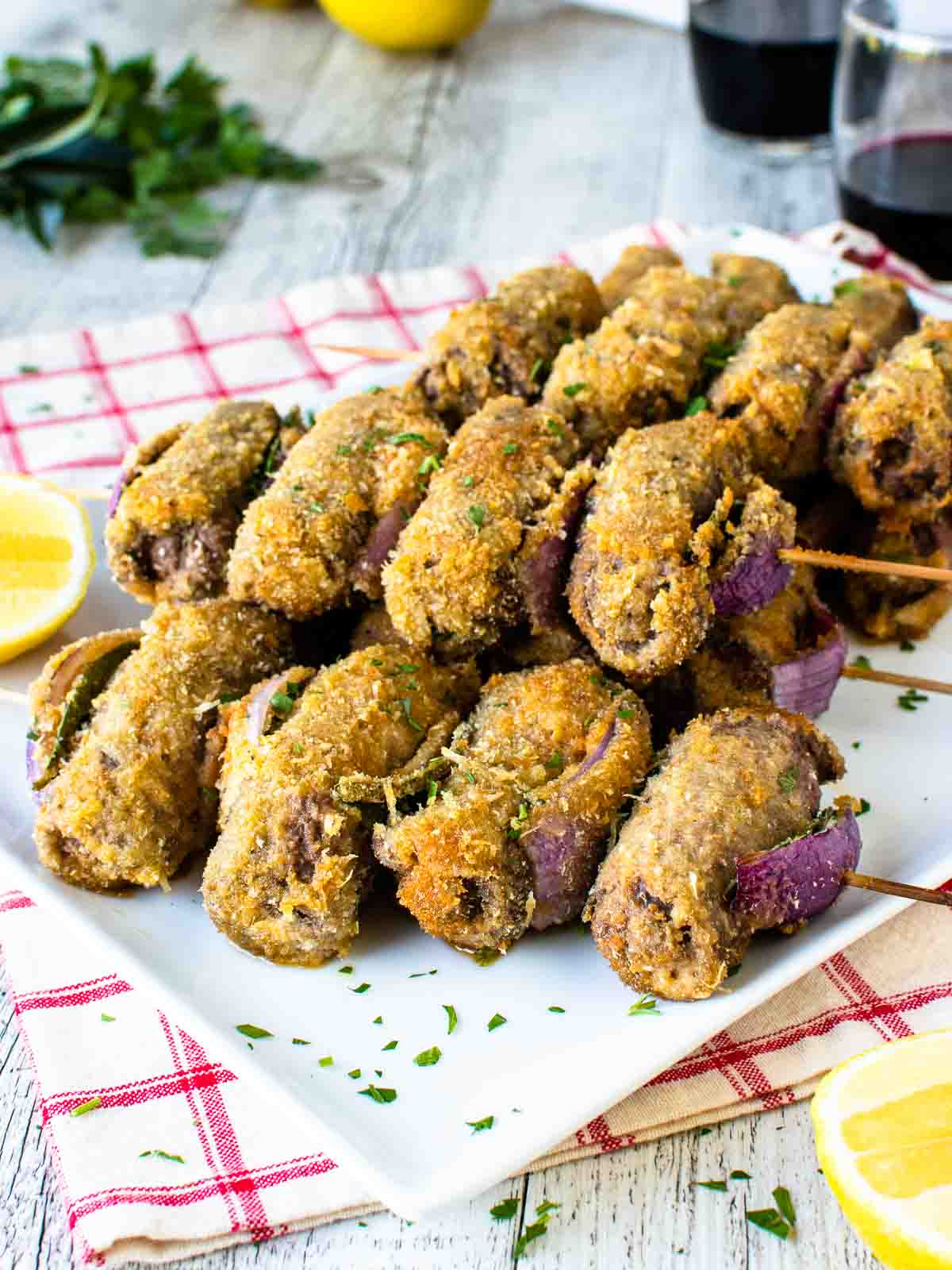 Spiedini on wooden skewered piled onto a white plate.