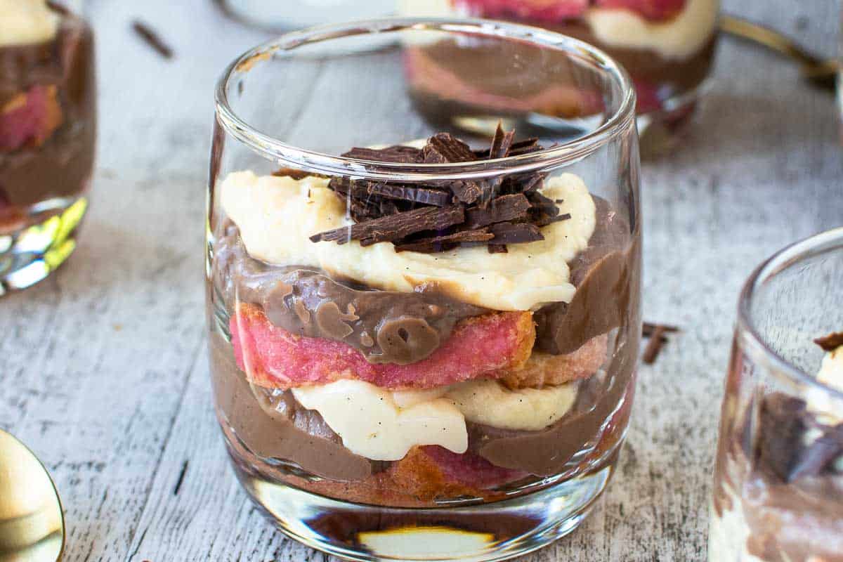 chocolate pudding in a teacups with a heaped spoonful of pudding resting on the top of the cup