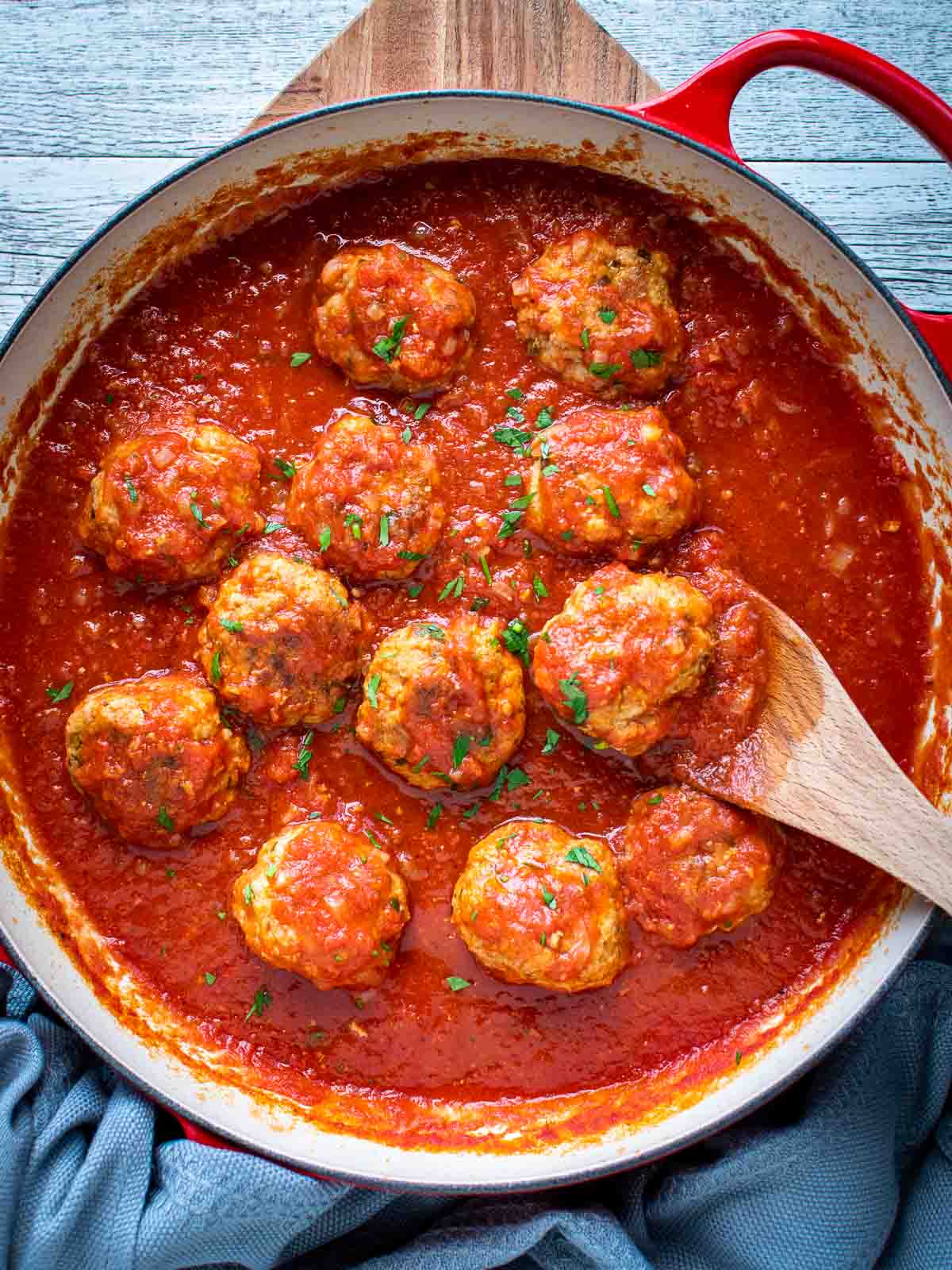 Italian Sausage Meatballs in tomato sauce in a pan viewed from above.