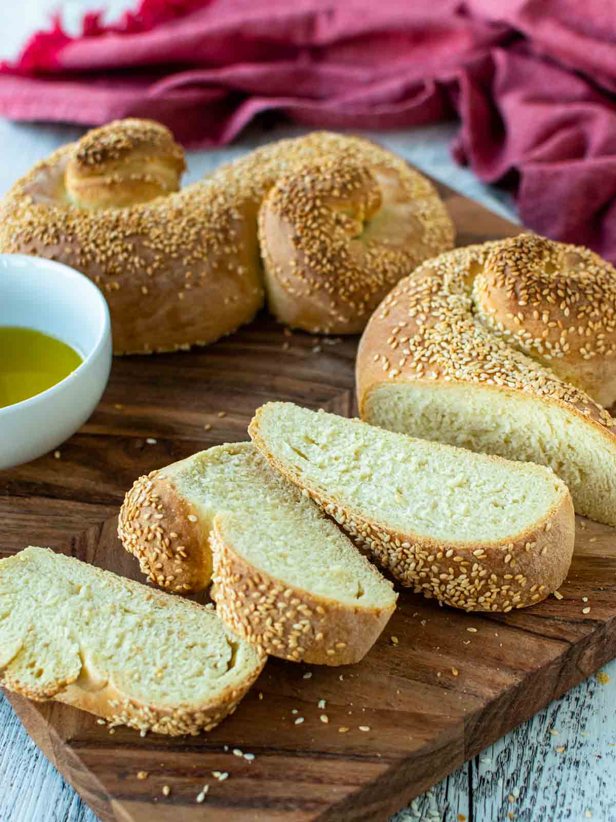 Semolina bread with three slices cut all on wooden board.