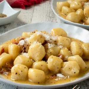 Gnocchi carbonara on a white plate.