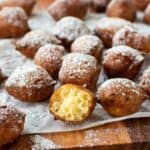 Close up of Italian ricotta donuts with one cut in half.