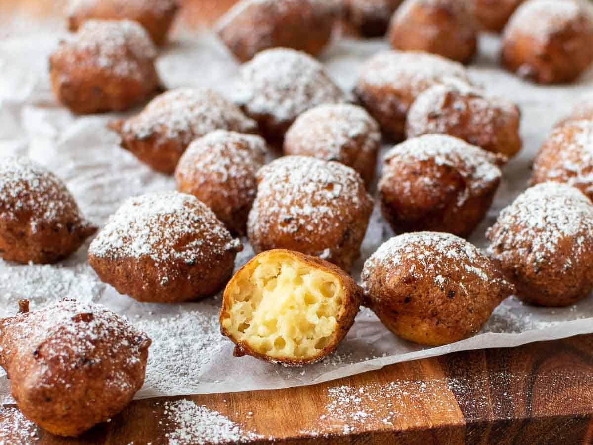 Close up of Italian ricotta donuts with one cut in half.