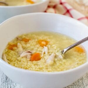 Chicken Pastina Soup in a white bowl with second bowl in the background.