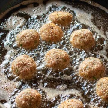 Meatballs frying in oil.