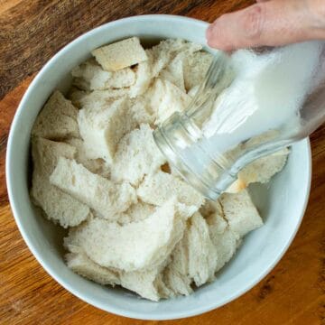 Milk being pour from a bottle onto white bread.