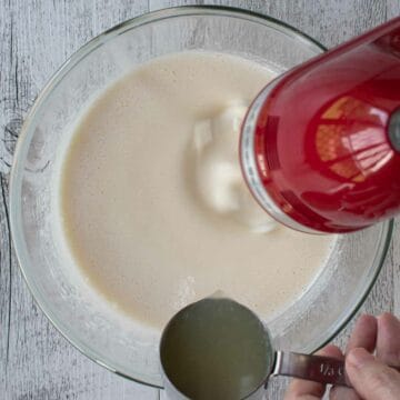 Adding lemon juice to beaten eggs and sugar using red hand held electric mixer.