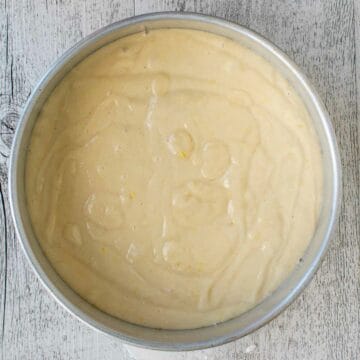 Cake batter in a round cake pan viewed from above.