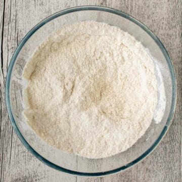 White flour in a glass bowl viewed overhead.