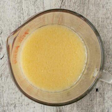 Overhead view of yellow liquid in a glass jug.