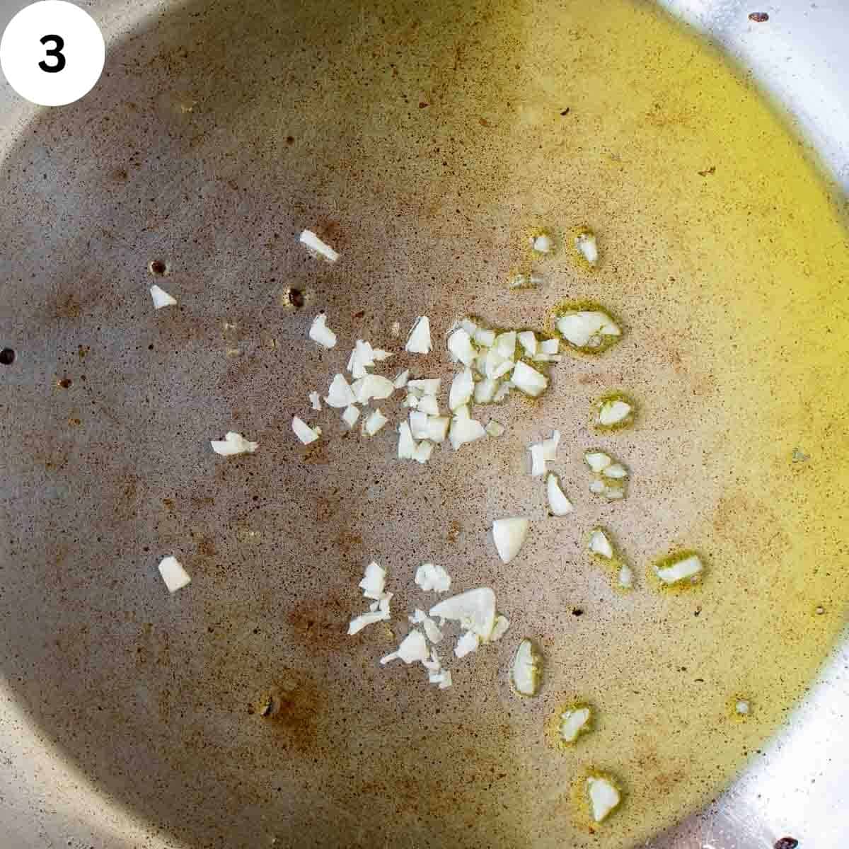 Chopped garlic frying in oil.