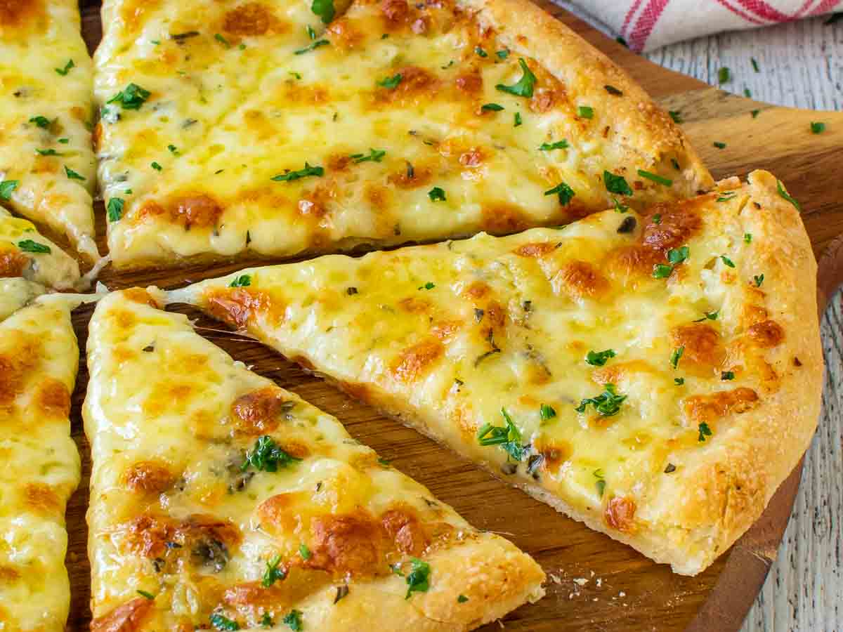 Close up of cheese pizza cut into wedges.