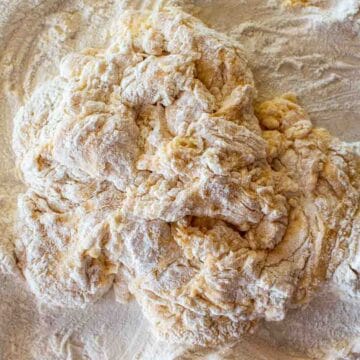 Scraggy dough with flour around viewed from above.