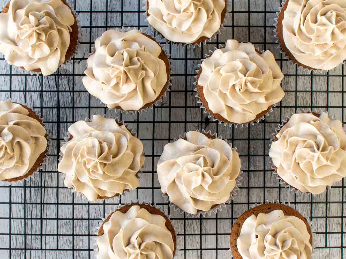 Off white buttercream swirled onto cupcakes viewed from above.