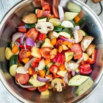 Assorted chopped vegetables in a stainless steel bowl viewed from above.