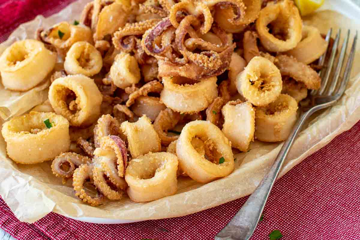 Closeup of calamari rings and tentacles that have been fried until golden brown.