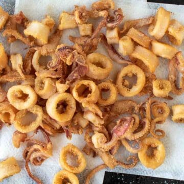 Fried calamari rings and tentacles on paper towel.
